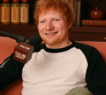 a man sitting on a couch holding a microphone